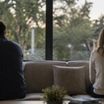 Two people sitting apart reflecting emotional distance in a relationship